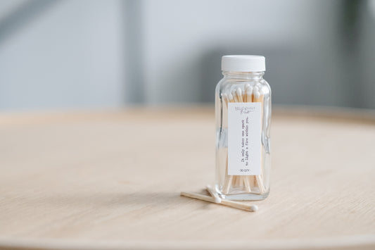 Small glass bottle with safety matches on a wooden surface