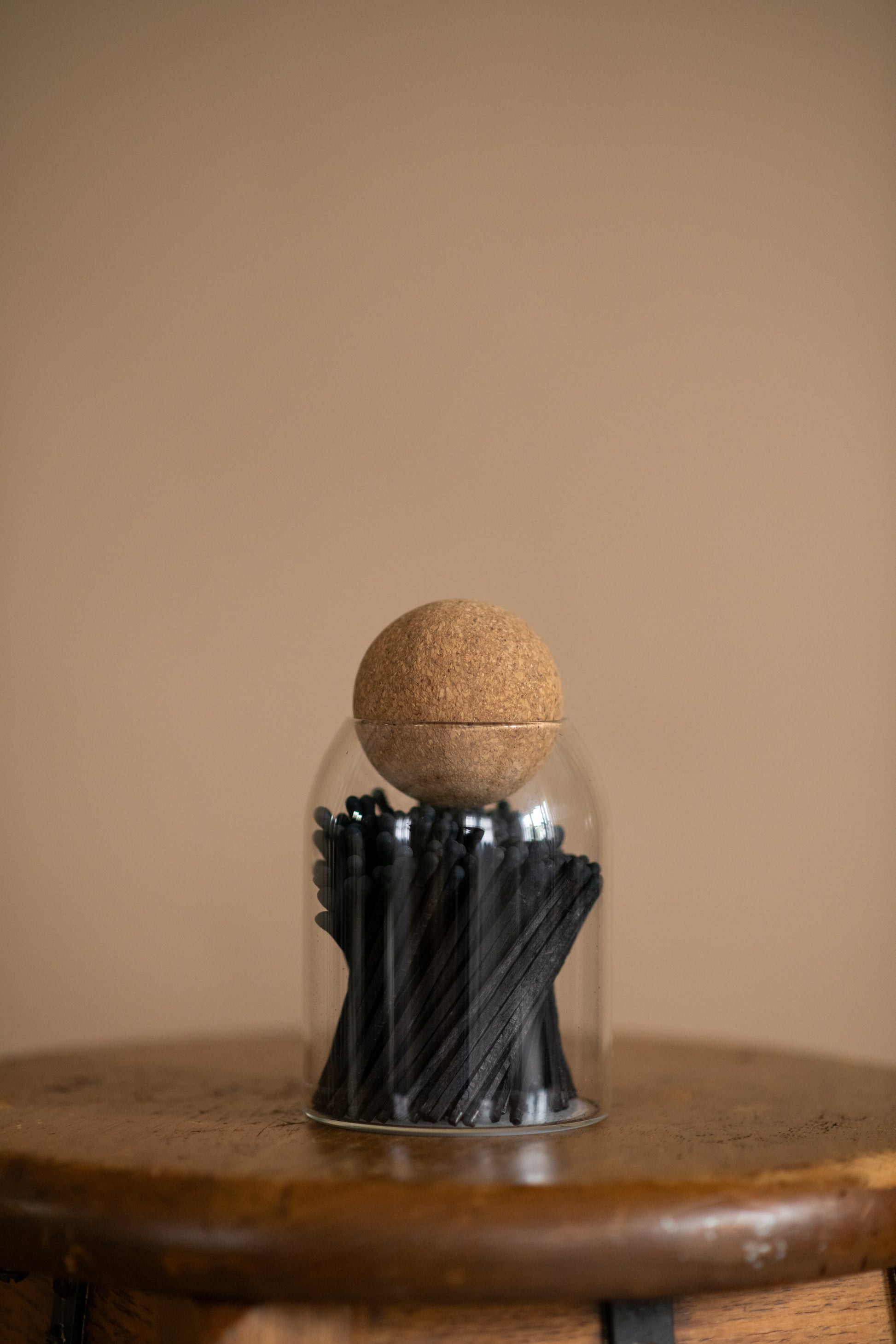 Deliciously Wickt 3.4-inch all black long stick safety matches displayed upright in a clear glass jar with cork stopper.