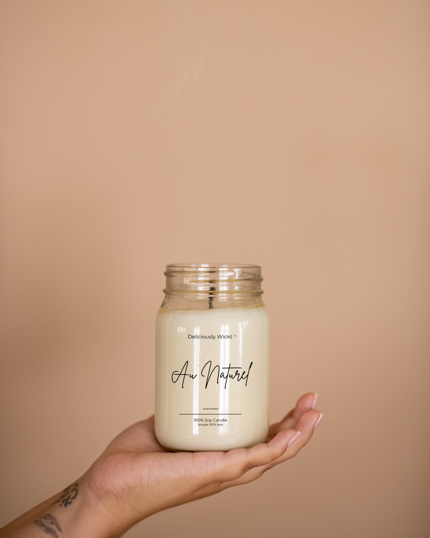 Au Naturel unscented soy candle in a clear mason jar held in one hand