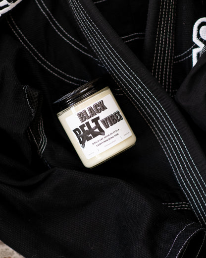 Black Belt Vibes Jiu-Jitsu soy candle displayed on a black gi