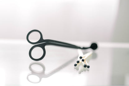 Deliciously Wickt black metal candle wick trimmer displayed on a light background.