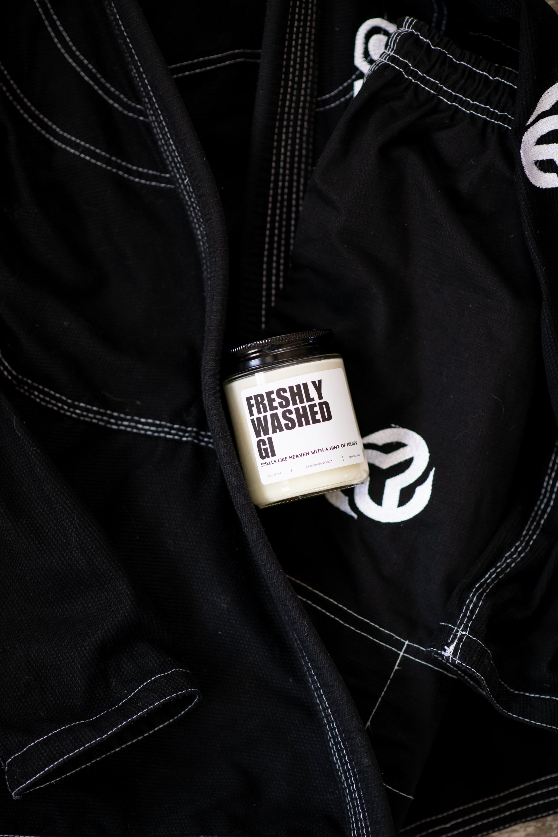 Freshly Washed Gi Jiu-Jitsu soy candle displayed on a black gi