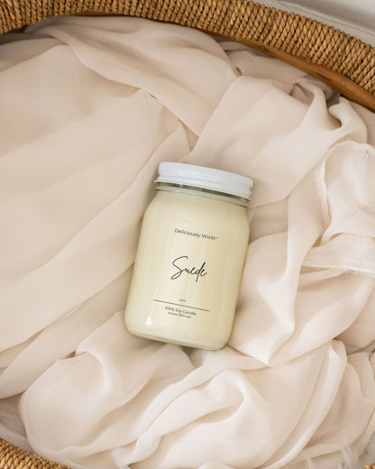 Deliciously Wickt Going, Going, Gone 16 oz mason jar soy candle resting on soft neutral fabric.