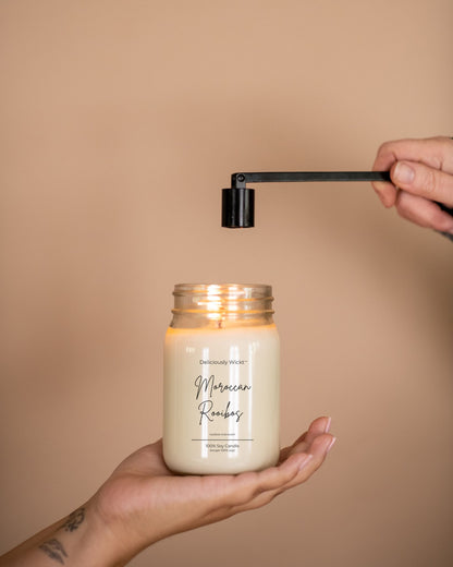 Deliciously Wickt Going, Going, Gone 16 oz mason jar soy candle being lit with a lighter.