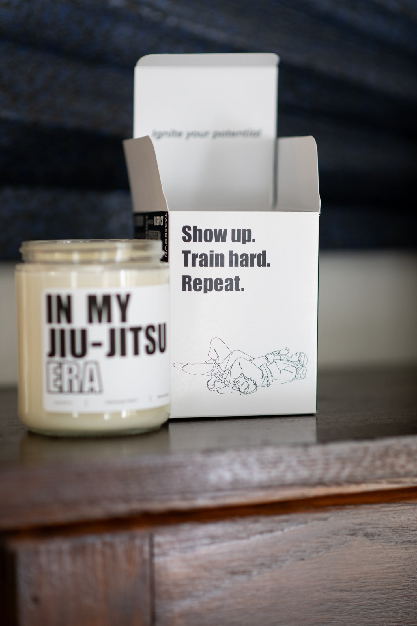 Deliciously Wickt In My Jiu-Jitsu Era 8 oz soy candle displayed beside its product box on a wooden surface.