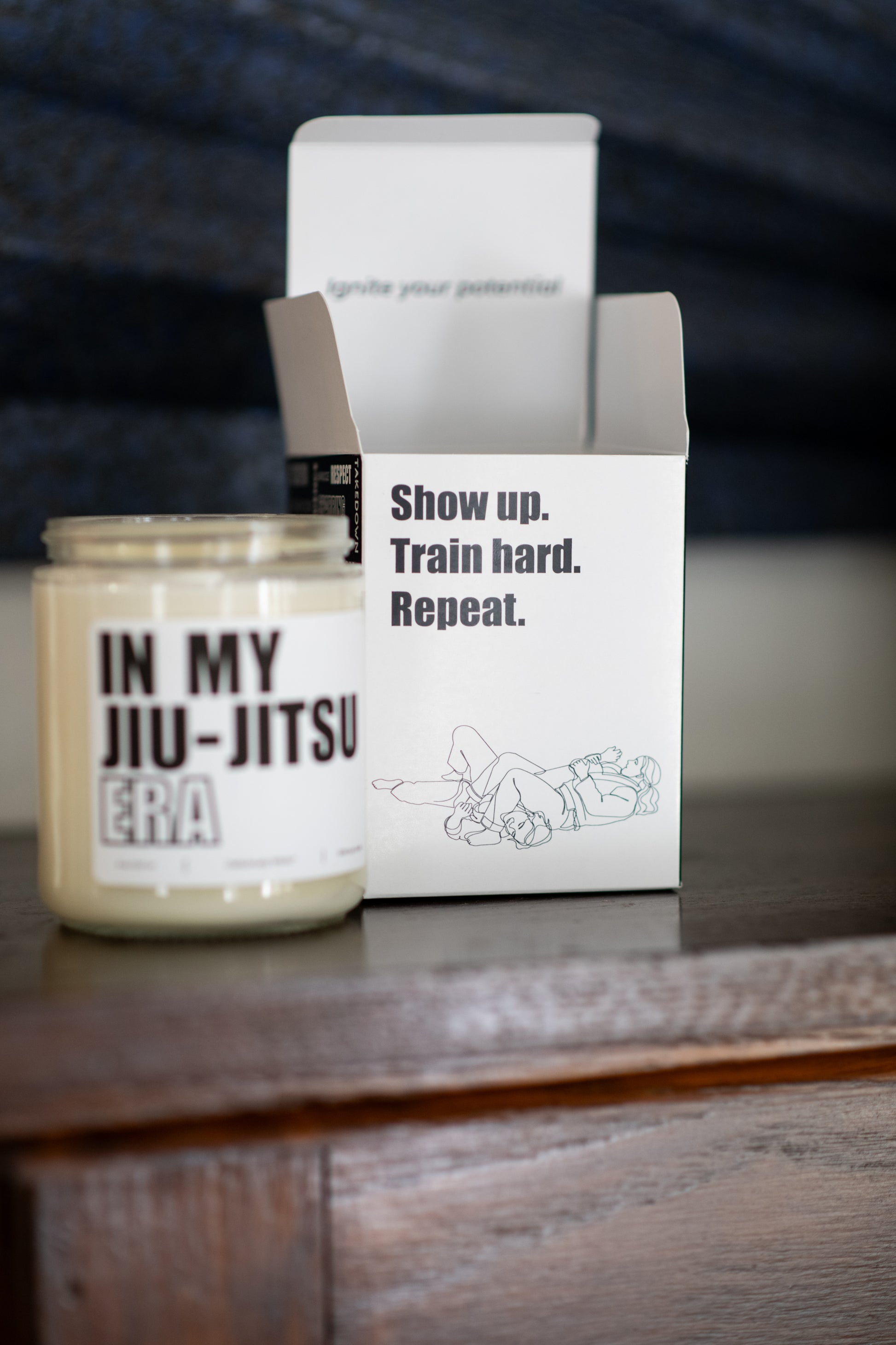 Deliciously Wickt In My Jiu-Jitsu Era 8 oz soy candle displayed beside its product box on a wooden surface.