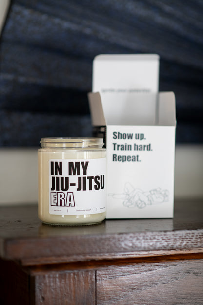 Deliciously Wickt In My Jiu-Jitsu Era 8 oz soy candle and product box displayed together on a wooden surface.