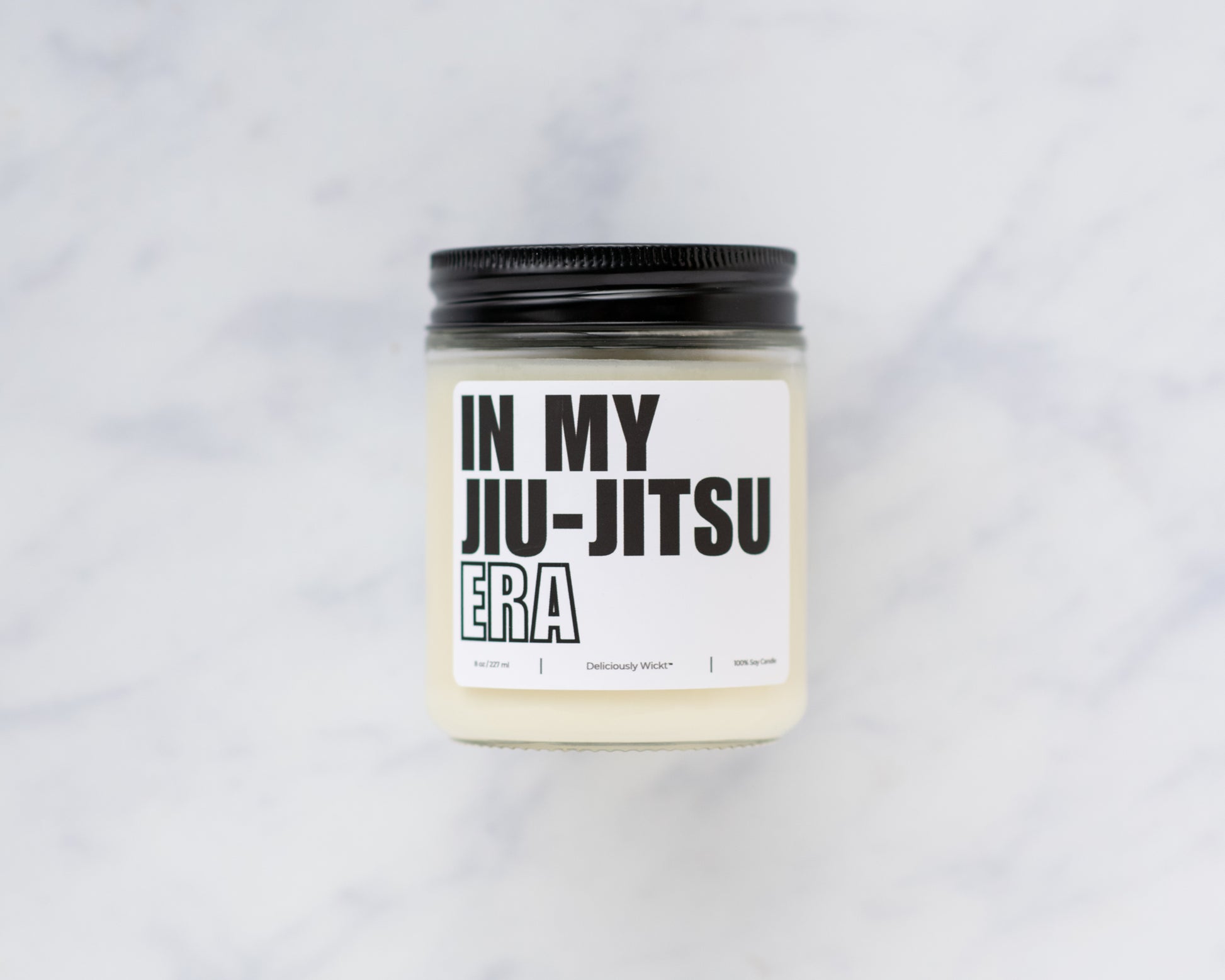 Deliciously Wickt In My Jiu-Jitsu Era 8 oz soy candle and product box displayed on a light background.