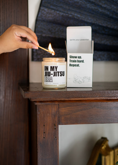 Deliciously Wickt In My Jiu-Jitsu Era 8 oz soy candle displayed with its product box on a dark wooden table.
