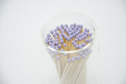 Deliciously Wickt lilac-tipped long stick safety matches photographed from above in a clear glass container.