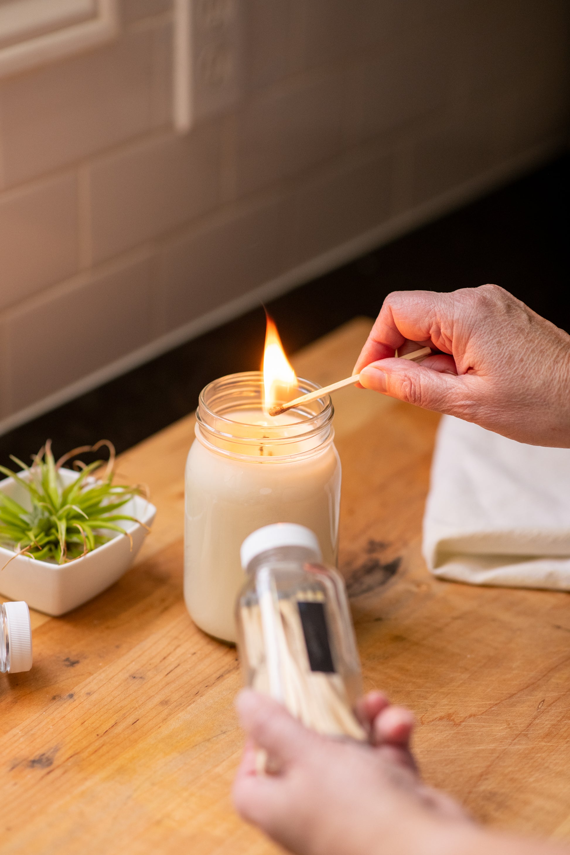 Deliciously Wickt long stick safety match being used to light a soy candle.