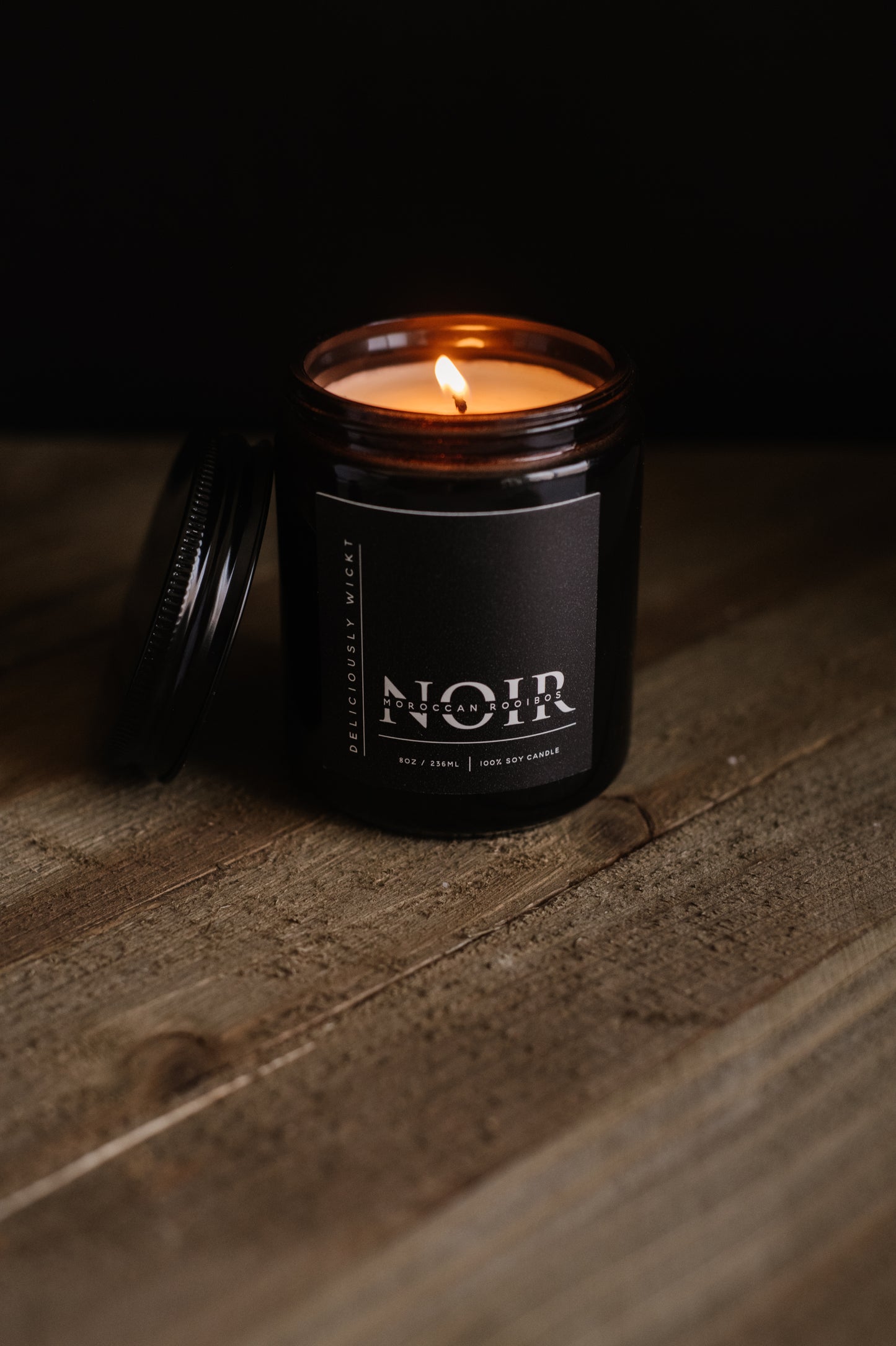 Moroccan Rooibos NOIR black soy candle displayed against a dark background