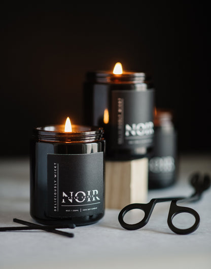 NOIR Trio black soy candles styled with candle care accessories