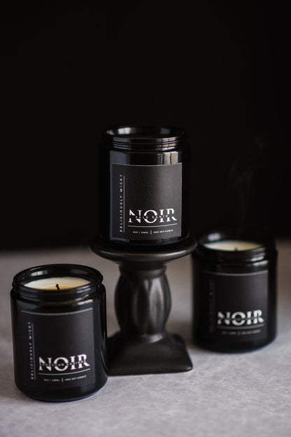 NOIR Trio of black soy candles grouped against a dark background