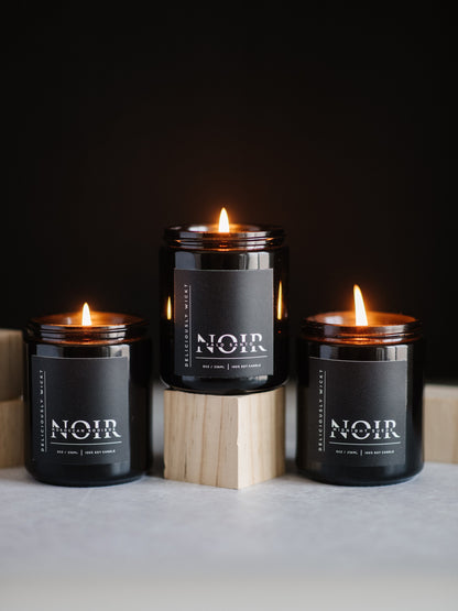 NOIR Trio of three 8 oz black soy candles burning in a styled display
