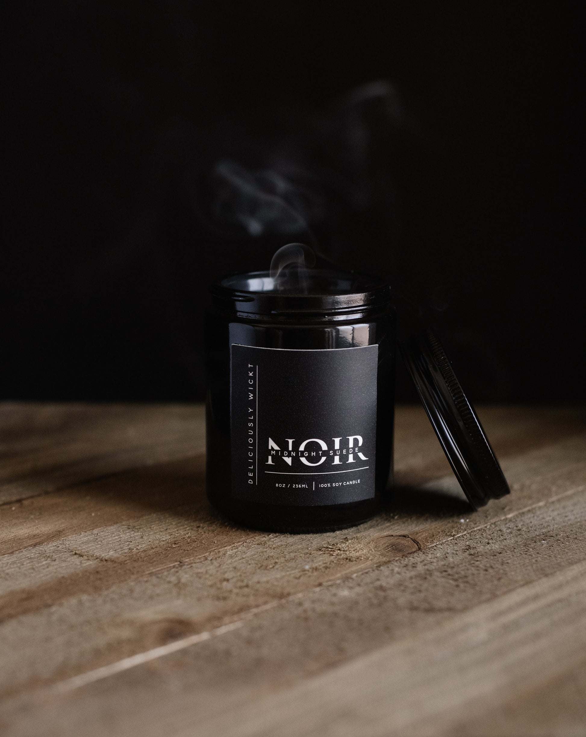 Single NOIR black soy candle displayed on a wooden surface