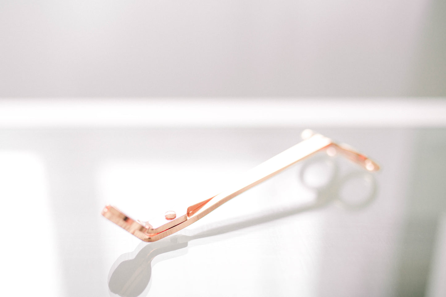 Deliciously Wickt rose gold metal candle wick trimmer displayed on a light background.